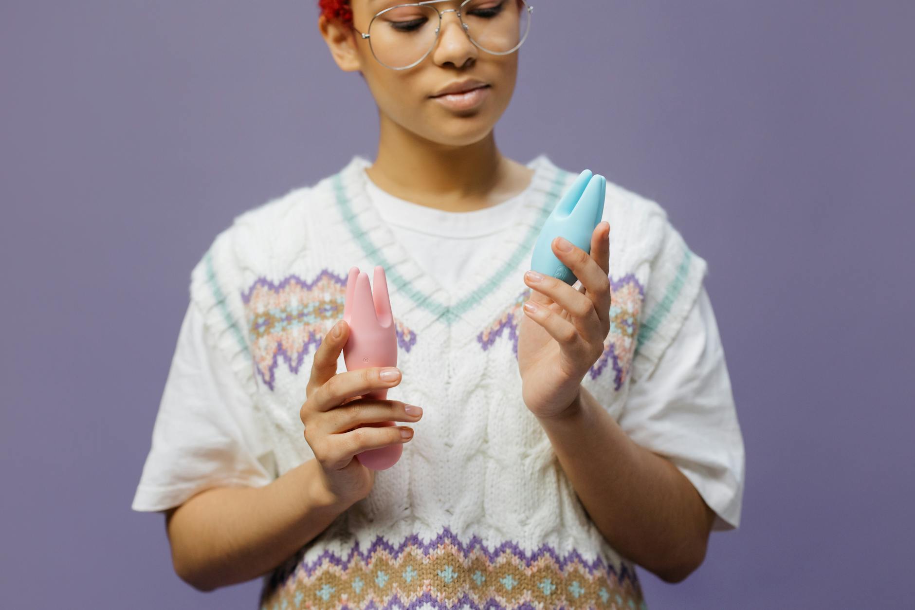 Woman holding silicone vibrators with thoughtful expression, representing intimate wellness during life transitions.